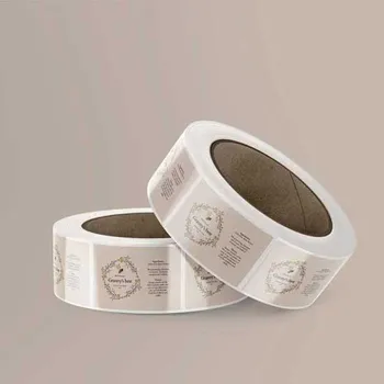 2 Rolls of rectangular paper Labels stacked together. The labels are honey labels with a detailed floral drawing on them