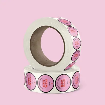 2 rolls of circle synthetic-polypropylene labels stacked together. The labels are pink and have red text reading body wash.